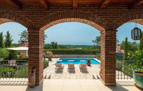 une arche en briques avec une piscine dans une cour dans l'établissement Lovely Home In Kastelir, à Kaštelir
