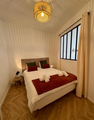 a bedroom with a large bed with two towels on it at À Deux Pas du Palais in Avignon