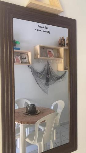a mirror in a room with a table and chairs at Casa a beira Mar - Ponta de Mangue - Maragogi in Maragogi