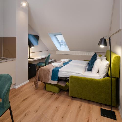 a bedroom with a bed and a green couch at CHLOE Hotel Budapest in Budapest