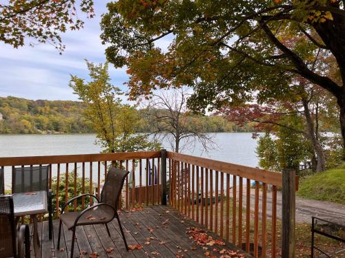 a wooden deck with chairs and a table and a view of a lake at Camping Chalets Lac St-Augustin in Quebec City