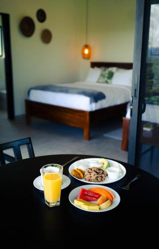 a table with two plates of food and a glass of orange juice at Cabañas Vista Verde opción sin jacuzzi in San Vito