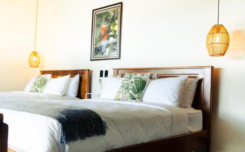 a bedroom with two beds with white pillows at Cabañas Vista Verde opción sin jacuzzi in San Vito