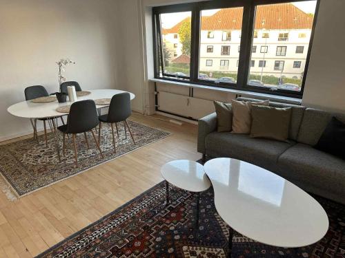 a living room with a couch and a table at Bright & cozy city apartment in Hvidovre
