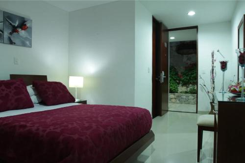 a bedroom with a bed with a purple blanket at Hotel Cariongo Pamplona in Pamplona