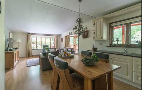 a kitchen and living room with a wooden table and chairs at Stunning Home In Erm With Sauna in Erm