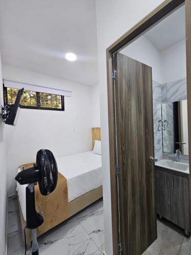 a bedroom with a bed and a bathroom with a mirror at Casa Eterna Campo Valdés in Medellín