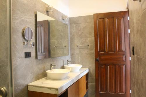 a bathroom with two sinks and a mirror at Hotel Casa Vivaldi in Mérida