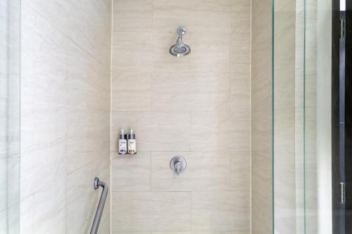 a shower with a glass door with two bottles at Holiday Inn Express & Suites Puebla Angelopolis by IHG in Puebla