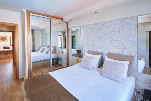 a bedroom with a large white bed with a stone wall at Ericeira Sunset Lifestyle II in Ericeira