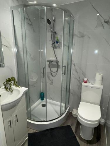 a bathroom with a shower and a toilet and a sink at Ideal Heathrow Base 2BR 2BA Apt in Hounslow in Hounslow