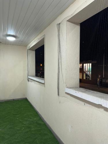 a room with a green floor and a window at Ideal Heathrow Base 2BR 2BA Apt in Hounslow in Hounslow