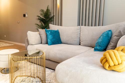 a living room with a couch and blue pillows at Kaltak Luxury Stay in Bar