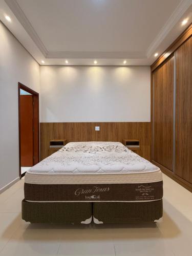 a bed in a room with a large mattress at Sua casa em Orlândia in Orlândia