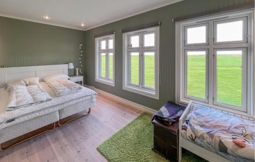 a bedroom with two beds and two windows at Luxurious Home In Kleppe With Wifi in Orre