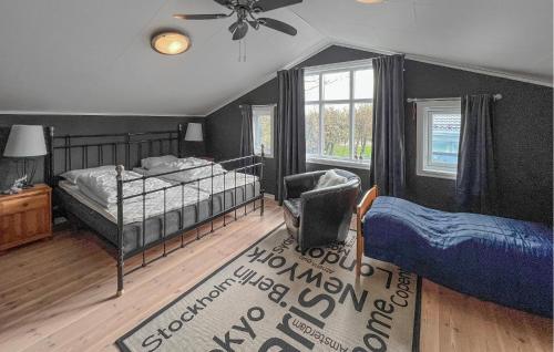 a bedroom with a bed and a chair and a fan at Luxurious Home In Kleppe With Wifi in Orre