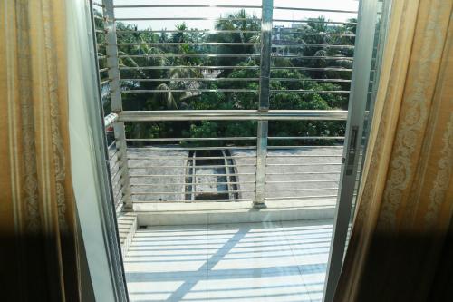 a dog looking out the window of a balcony at Rayhan's in Cox's Bazar