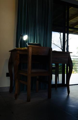 a wooden desk with a chair and a lamp on it at Cabañas Vista Verde opción con jacuzzi in San Vito