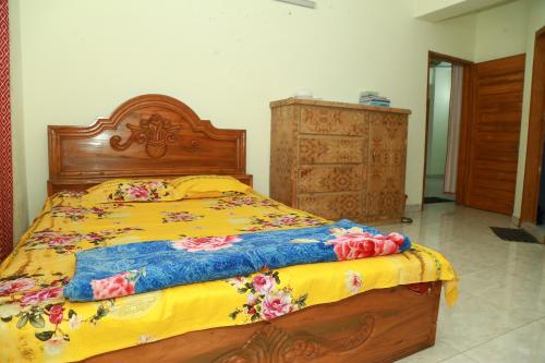 a bedroom with a bed with a yellow and blue comforter at Rayhan's in Cox's Bazar
