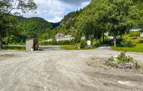 a dirt road with a building on the side of a mountain at Gorgeous Home In Lavik With House Sea View in Vikum