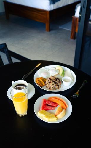two plates of food and a glass of orange juice at Cabañas Vista Verde opción con jacuzzi in San Vito