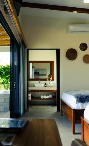 a bedroom with a bed and a bathroom with a mirror at Cabañas Vista Verde opción con jacuzzi in San Vito