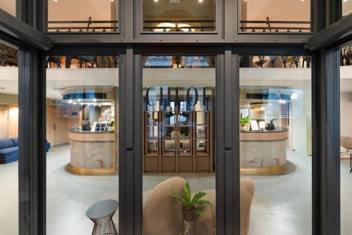 a view of a lobby with glass doors and chairs at CHLOE Hotel Budapest in Budapest