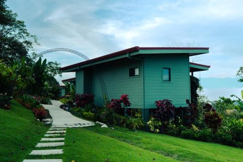 a green building with a roller coaster in the background at Cabañas Vista Verde opción con jacuzzi in San Vito