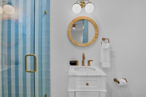 a bathroom with a sink and a mirror and a shower at Driftwood Villas at Anna Maria Island Inn in Holmes Beach