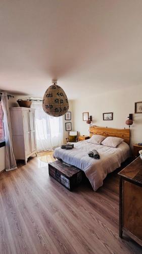 La Maison de Rose في بوي ليه باروني: غرفة نوم بها سرير كبير وثريا كبيرة
