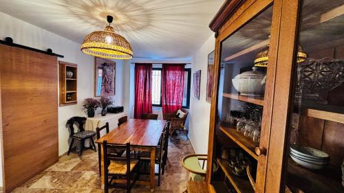 La Maison de Rose في بوي ليه باروني: غرفة طعام بها طاولة خشبية وثريا