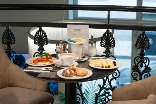 a table with plates of food on a balcony at CHLOE Hotel Budapest in Budapest