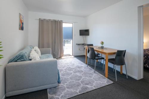 una sala de estar con un sofá y una mesa en Aotea Motel, en Christchurch