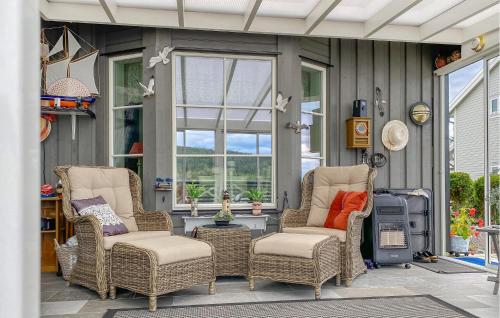 a patio with wicker chairs and a table at Stunning Home In Skåla With House A Panoramic View in Røvik