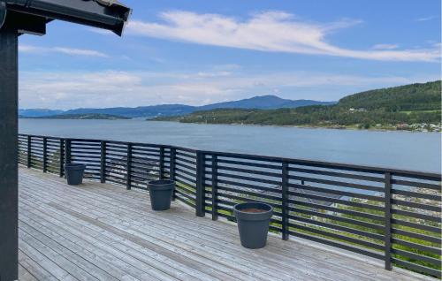 a pier with three trash cans on the side of a lake at Stunning Home In Skåla With House A Panoramic View in Røvik