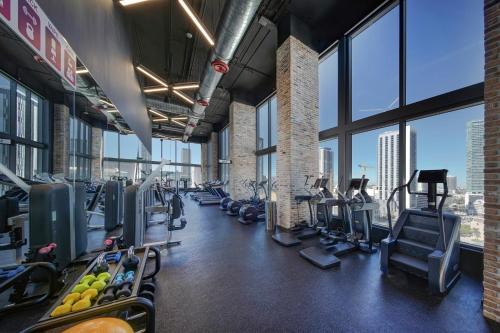 a gym with treadmills and ellipticals in a building with windows at Cadenza Miami - Luxury Residences in Miami