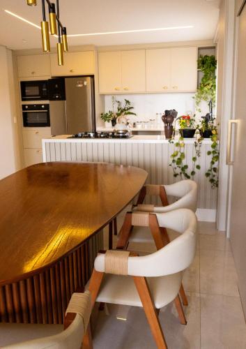 a kitchen with a wooden table and chairs at Apartamento Alto Padrão com Vista Para o Lago in Cascavel