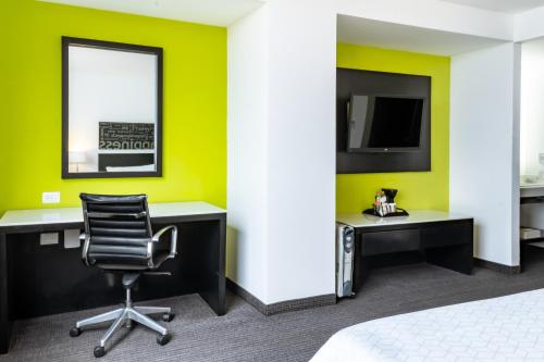 a room with a desk and a chair and a tv at Holiday Inn Express & Suites Puebla Angelopolis by IHG in Puebla