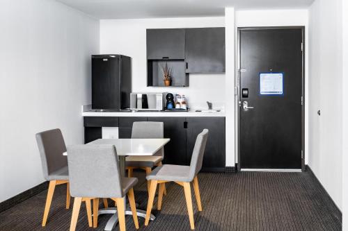 a dining room with a table and chairs and a kitchen at Holiday Inn Express & Suites Puebla Angelopolis by IHG in Puebla
