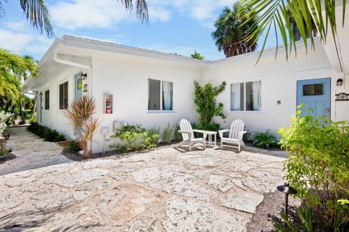 a white house with two chairs and a table at Driftwood Villas at Anna Maria Island Inn in Holmes Beach