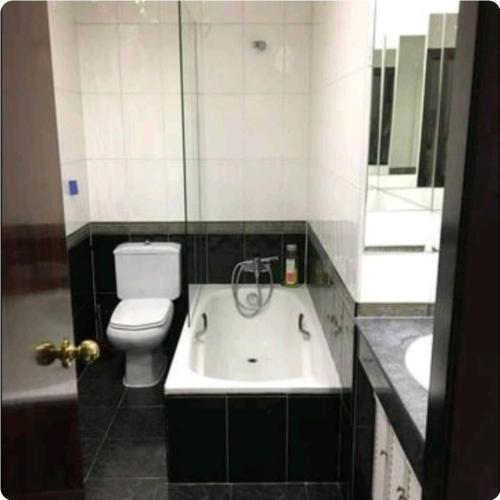 a bathroom with a white toilet and a sink at Duplex con Garaje in Villamayor