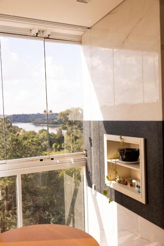 a room with a large window with a view at Apartamento Alto Padrão com Vista Para o Lago in Cascavel