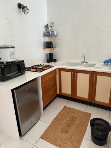 a kitchen with a stove top oven next to a sink at Vahihotu Location Saisonnière in Paraoro