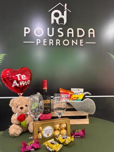 a table with a teddy bear and wine glasses at Pousada Perrone Antiga pousada Marins in Campos do Jordão