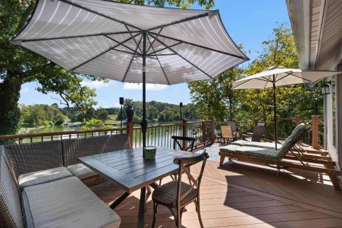 a table and chairs on a deck with an umbrella at Relaxing Lakefront Retreat w/ Hot Tub & Dock in Blountville