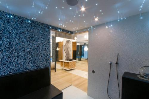 y baño con ducha y pared de azulejos azules. en Przystań Mechelinki- Marina Del Mar, en Mechelinki