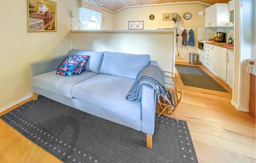 a blue couch in a room with a kitchen at Cozy Home In Läckeby With Wifi in Bäckebo