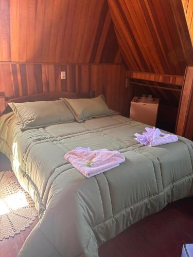 a bed with two towels on top of it at Pousada Perrone Antiga pousada Marins in Campos do Jordão