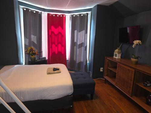 a bedroom with a bed and a chair and a television at Fashionably cozy2 in Meriden