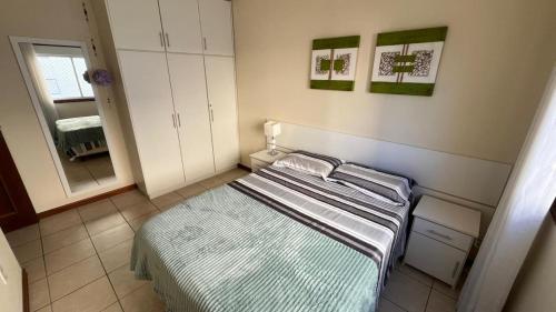 a small bedroom with a bed and a mirror at Apto CAPAO DA CANOA Ed GABRIELA 6 Pers in Capão da Canoa